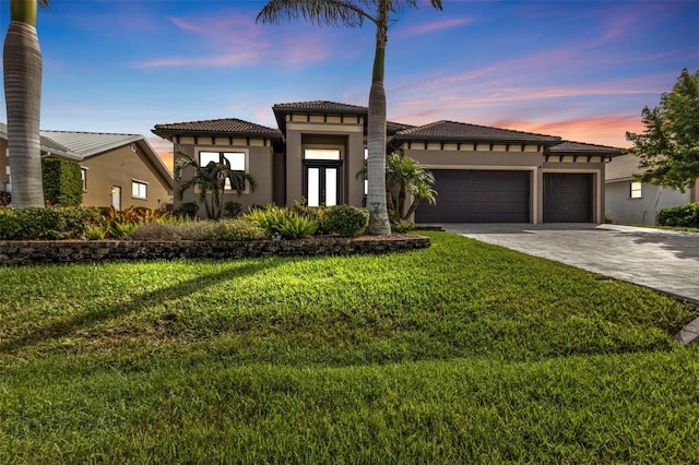 view of front of house with french doors, a yard, and a garage