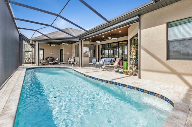 view of swimming pool with a patio, glass enclosure, and ceiling fan