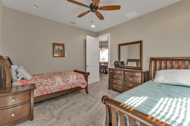 bedroom with ceiling fan with notable chandelier