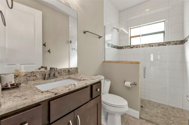 bathroom with tile patterned floors, vanity, an enclosed shower, and toilet