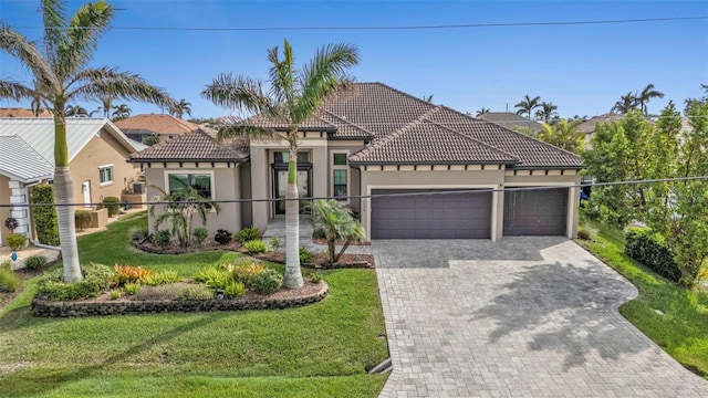 mediterranean / spanish-style house with a garage and a front lawn