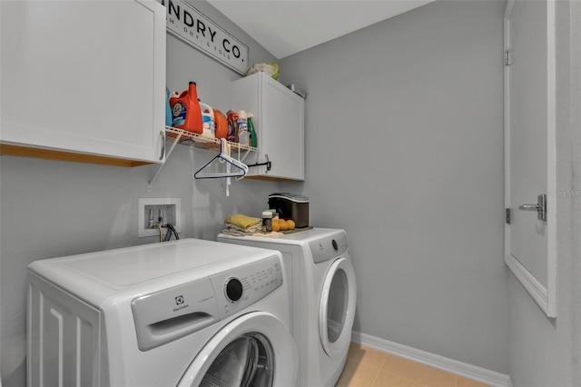 washroom with cabinets, separate washer and dryer, and light tile patterned floors