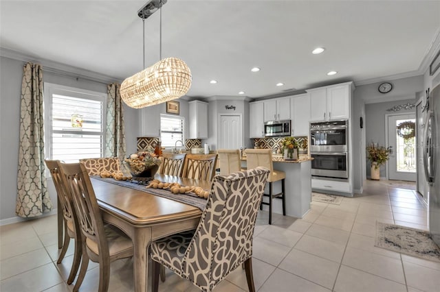 dining room with ornamental molding, light tile patterned floors, and an inviting chandelier