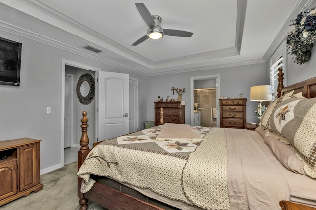 carpeted bedroom with a raised ceiling, ensuite bathroom, ceiling fan, and ornamental molding