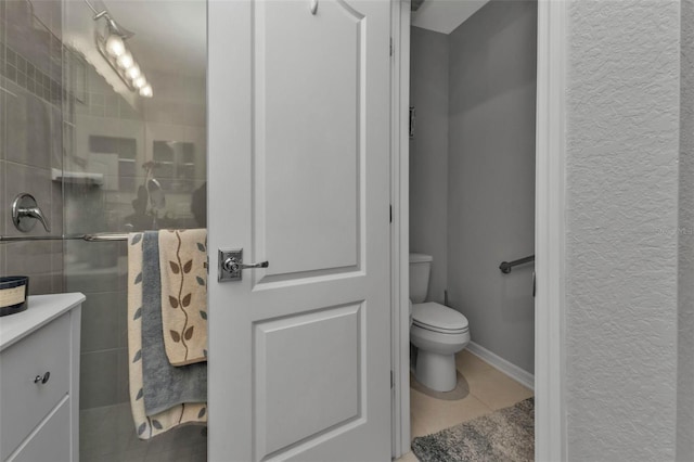 bathroom featuring tile patterned floors, toilet, vanity, and walk in shower