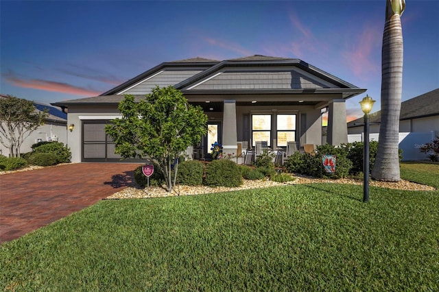 craftsman inspired home featuring a porch, a yard, and a garage