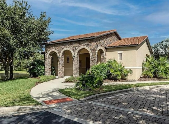 mediterranean / spanish house with a front yard