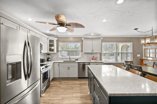 kitchen with decorative backsplash, white cabinetry, sink, and stainless steel appliances