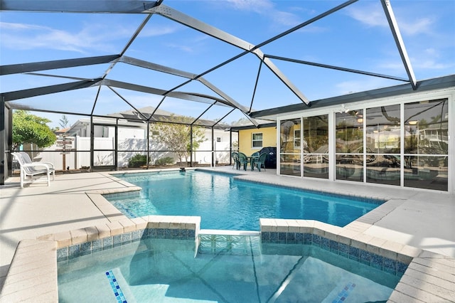 view of swimming pool with glass enclosure and a patio area