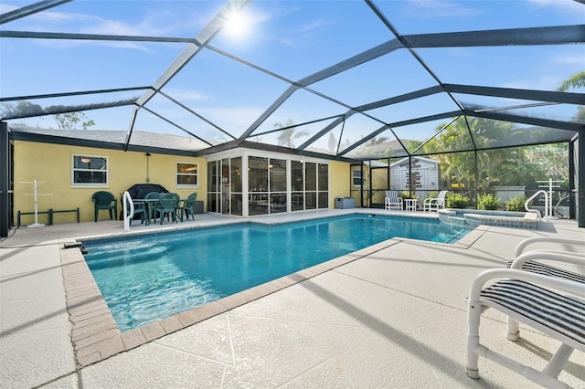 view of swimming pool featuring a patio area, a lanai, an in ground hot tub, and a storage shed