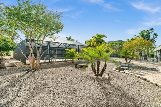 view of yard featuring glass enclosure and a patio area