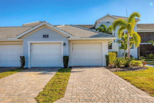 14070 Heritage Landing Blvd Unit 423, Punta Gorda, FL 33955 - view of front of home featuring decorative driveway, a garage, a tiled roof, and stucco siding