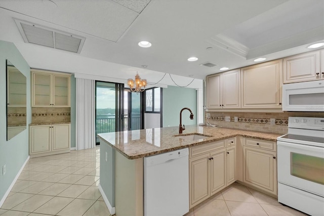 kitchen with white appliances, sink, light tile patterned floors, a notable chandelier, and kitchen peninsula