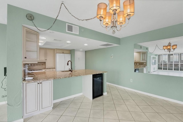 kitchen featuring backsplash, decorative light fixtures, white fridge, beverage cooler, and a chandelier