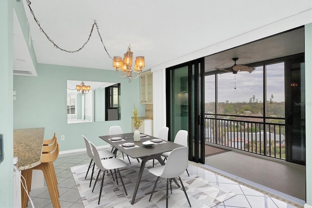 tiled dining room with plenty of natural light, a wall of windows, and ceiling fan with notable chandelier