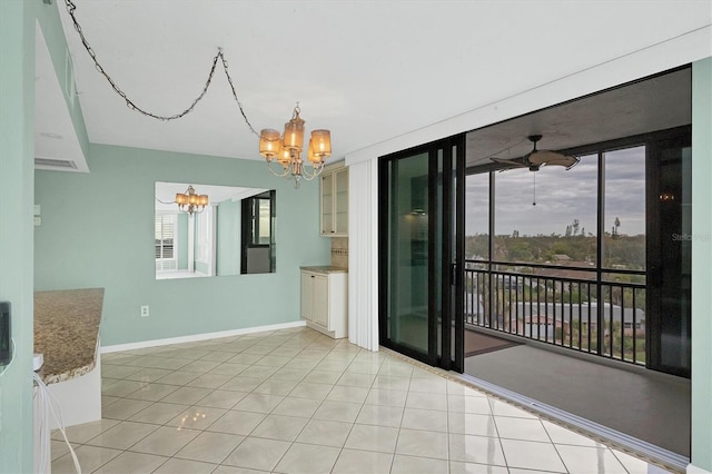 spare room featuring light tile patterned floors, ceiling fan with notable chandelier, and a wealth of natural light