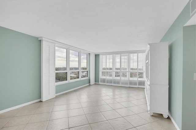 tiled spare room featuring a wealth of natural light