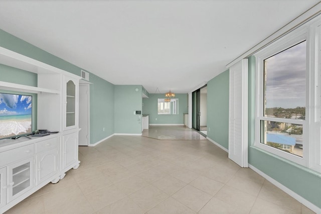 unfurnished living room featuring a chandelier