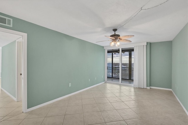 tiled spare room featuring ceiling fan