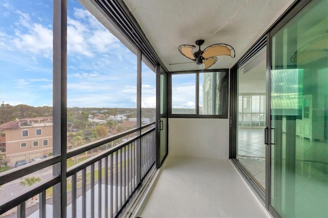 unfurnished sunroom with ceiling fan