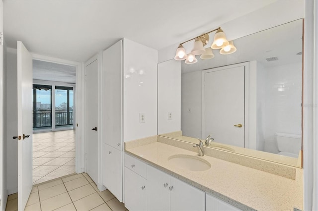 bathroom featuring tile patterned flooring, vanity, and toilet