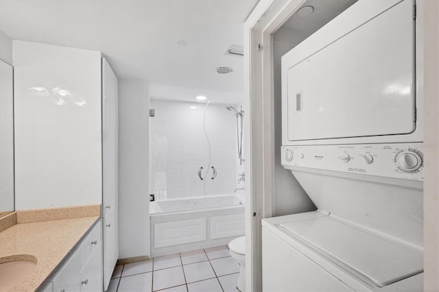 laundry room with stacked washer / drying machine, light tile patterned flooring, and sink