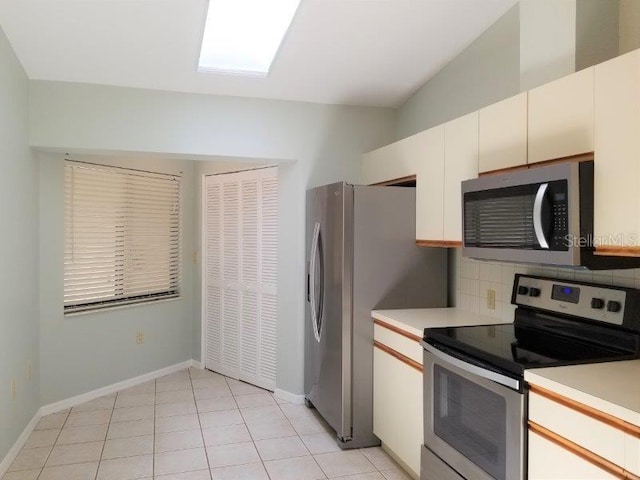 kitchen with white cabinetry, light tile patterned floors, appliances with stainless steel finishes, and tasteful backsplash