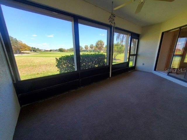 unfurnished sunroom featuring a wealth of natural light and ceiling fan