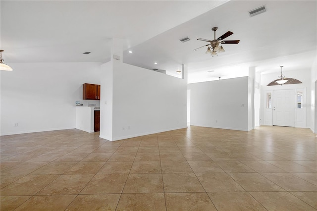 unfurnished living room with ceiling fan, light tile patterned floors, and vaulted ceiling