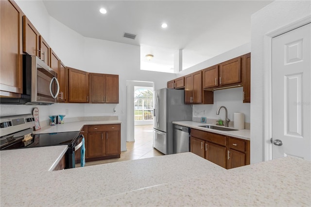 kitchen with kitchen peninsula, light tile patterned floors, stainless steel appliances, and sink