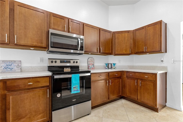 kitchen featuring light tile patterned flooring and appliances with stainless steel finishes