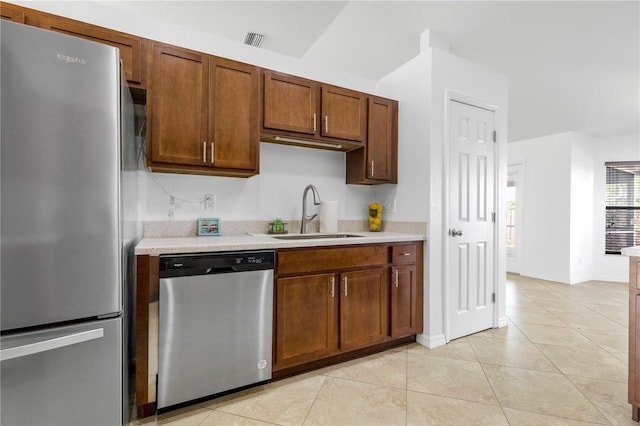 kitchen with appliances with stainless steel finishes, light tile patterned floors, and sink