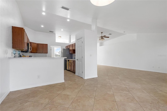 kitchen with ceiling fan, light tile patterned floors, stainless steel refrigerator, and vaulted ceiling