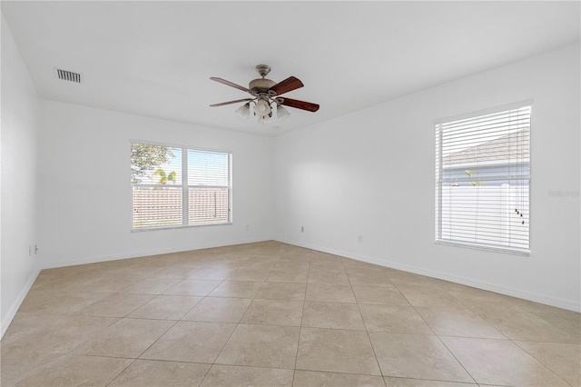 spare room with ceiling fan and light tile patterned floors