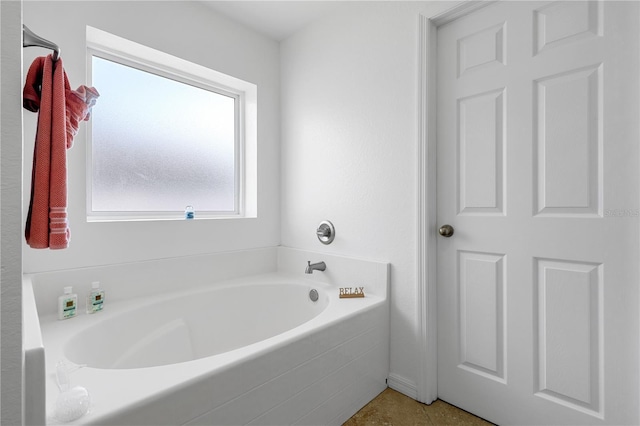 bathroom with tile patterned flooring and a tub to relax in