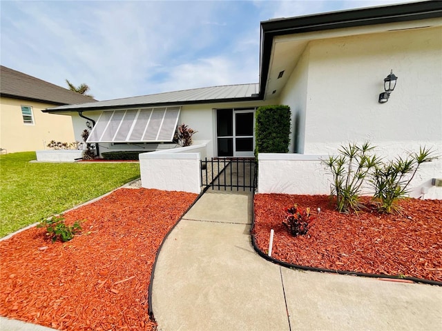 entrance to property with a lawn