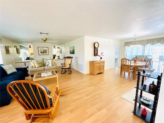 living room with light hardwood / wood-style floors and ceiling fan