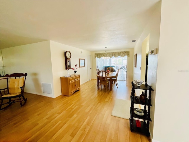 dining room featuring a notable chandelier and light hardwood / wood-style flooring