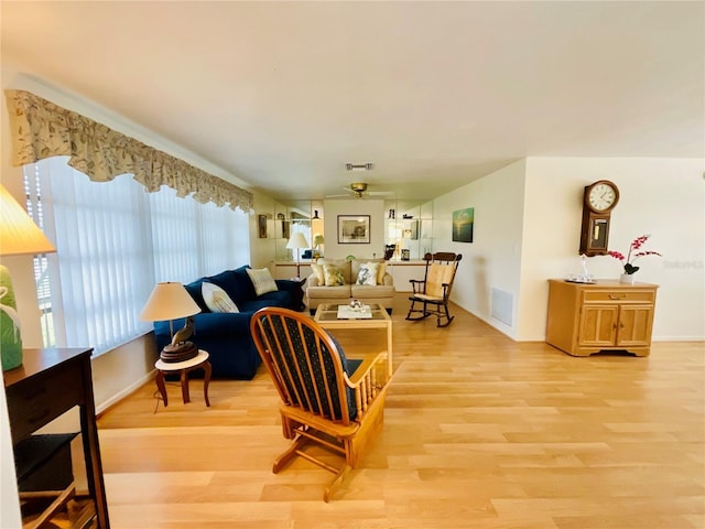 living room with ceiling fan and light hardwood / wood-style flooring