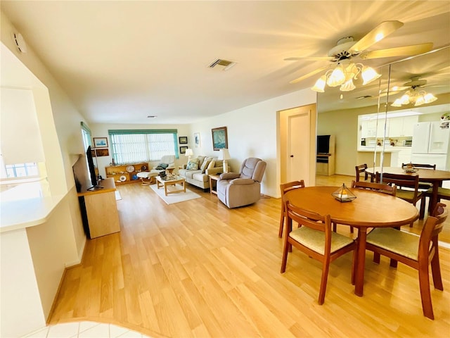 dining space with light wood-type flooring and ceiling fan