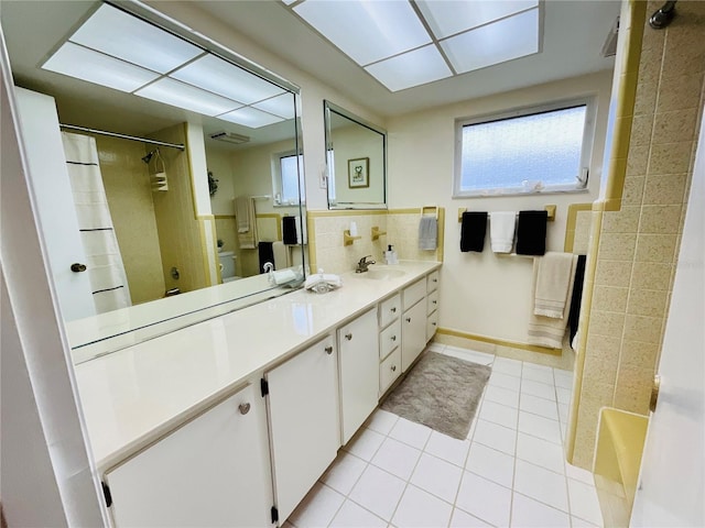 bathroom featuring tile patterned flooring, vanity, and backsplash