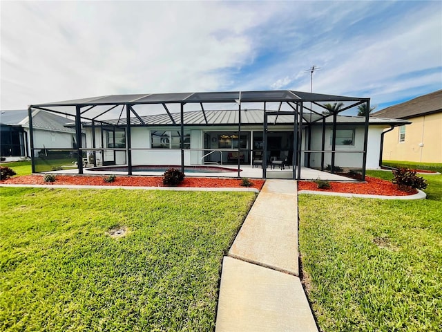 back of property with a lanai, a lawn, and a patio