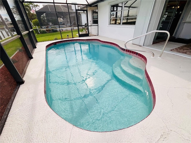 view of pool featuring glass enclosure