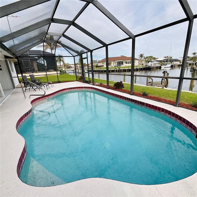 view of swimming pool with a lawn, glass enclosure, a patio area, and a water view