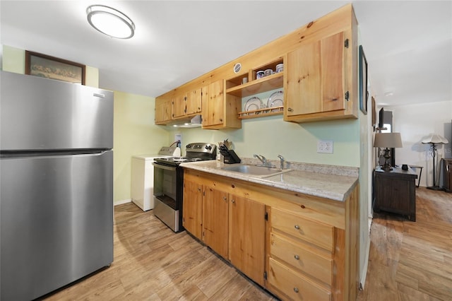 kitchen with separate washer and dryer, light wood-type flooring, stainless steel appliances, and sink