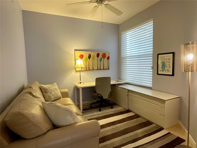 carpeted office space with ceiling fan and a healthy amount of sunlight