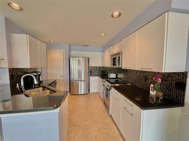 kitchen with light tile patterned floors, white cabinetry, sink, and appliances with stainless steel finishes