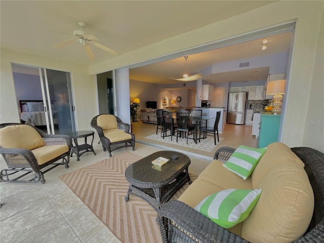 living room with ceiling fan and light tile patterned flooring