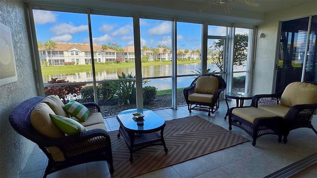 sunroom / solarium featuring a wealth of natural light, a water view, and ceiling fan