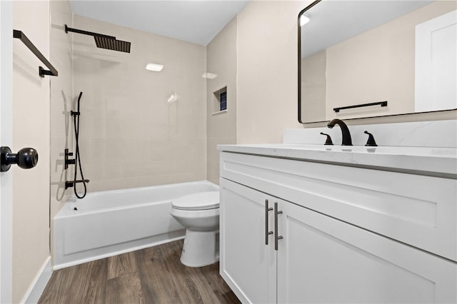 full bathroom featuring tiled shower / bath, vanity, wood-type flooring, and toilet